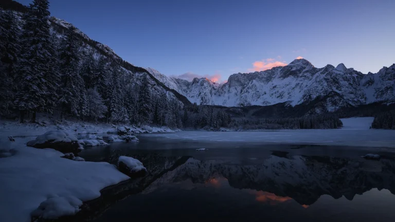 粉霞雪山冰封静水冬日森林山水实景