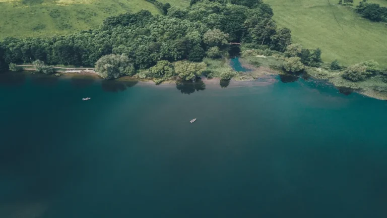 航拍碧绿湖泊森林草地湖面小船自然风光
